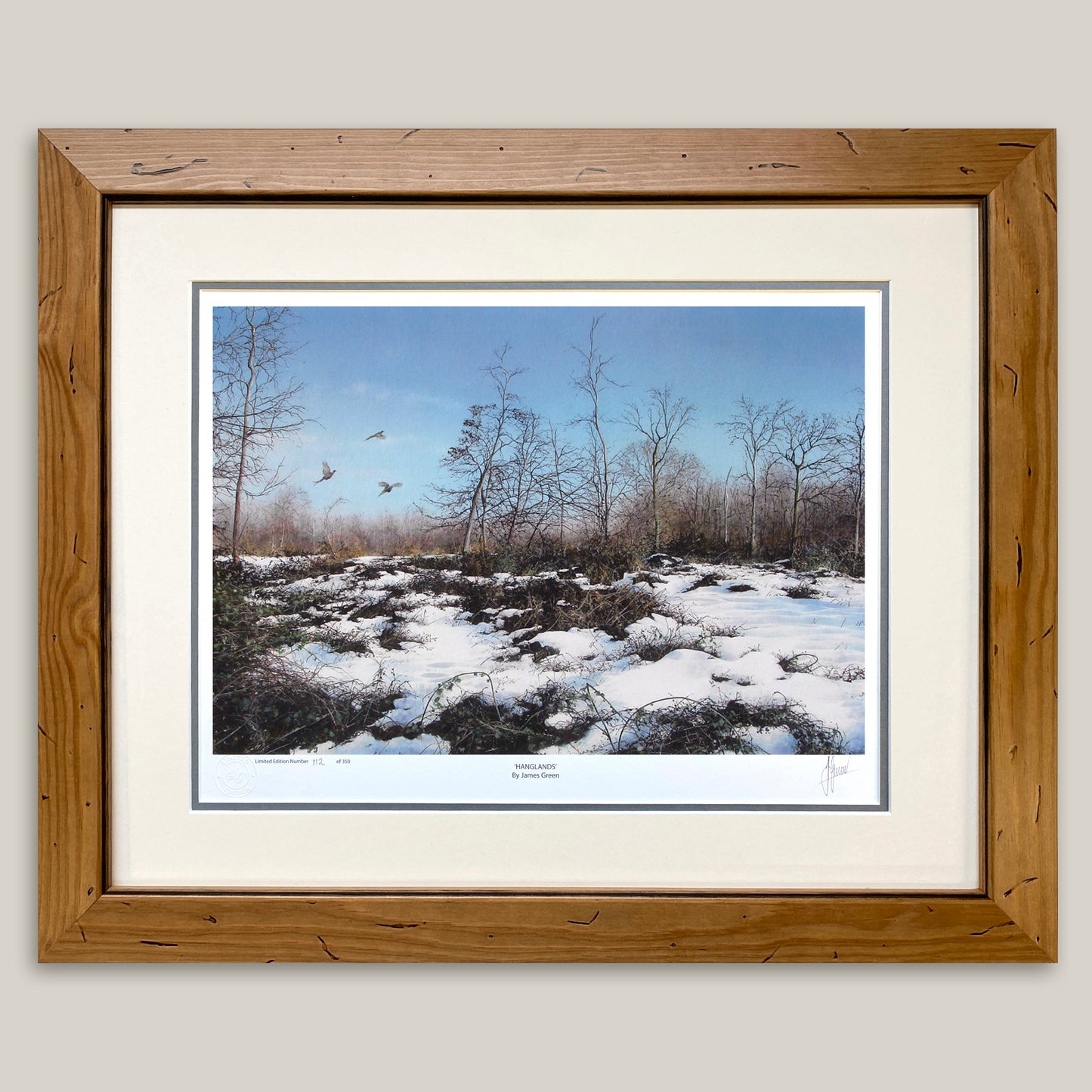 framed print of snow covered brambles with three pheasants  in flight in the background