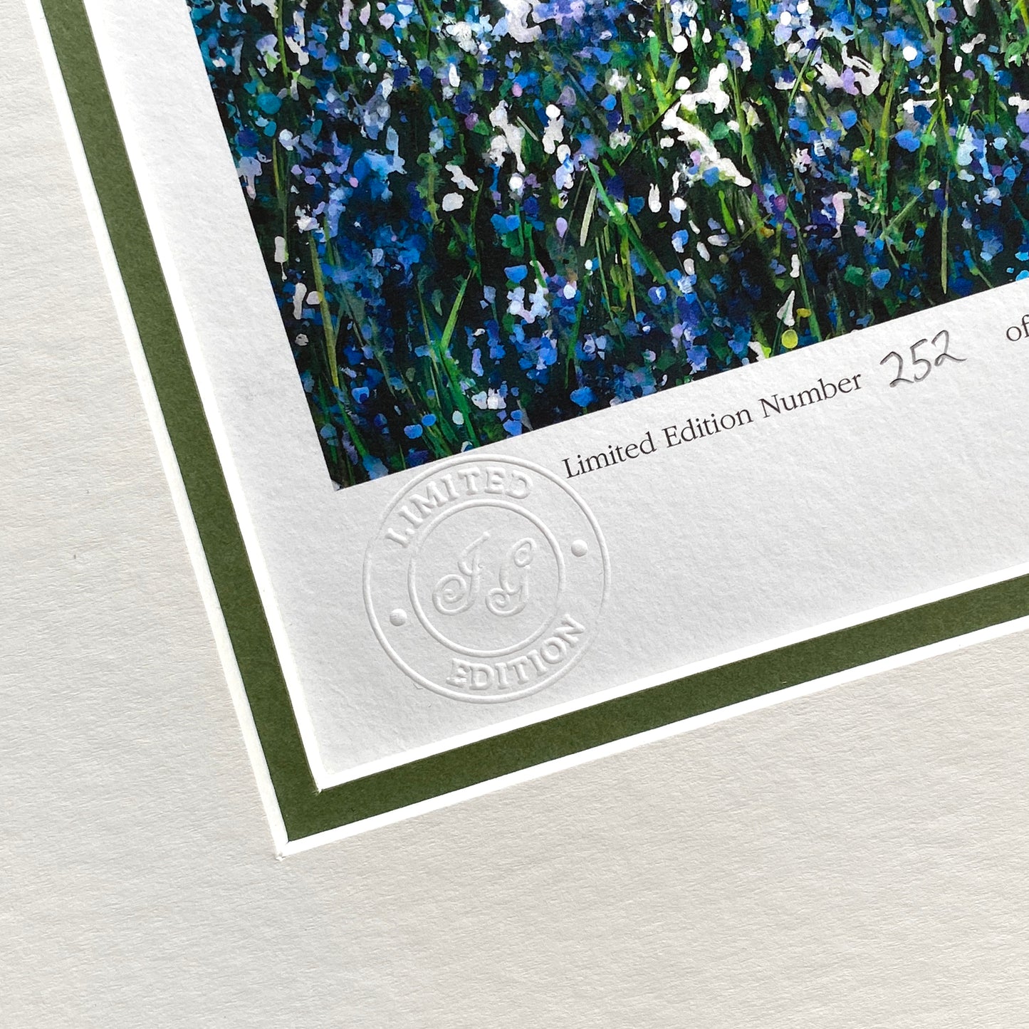 close up of corner of bluebell print with embossed limited edition stamp 